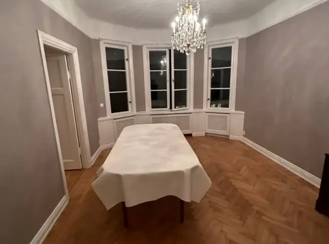 Renoverat rum med parkettgolv och äldre fönsterparti