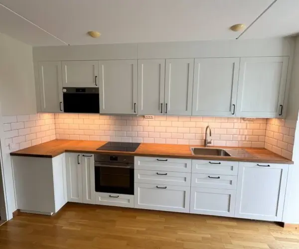 Kök med ljusa luckor och parkettgolv