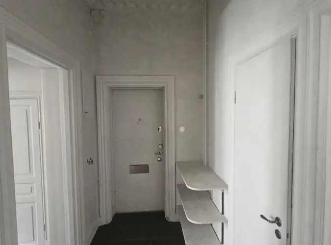 Hall med vita dörrfoder och målade snickerier